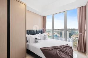 a bedroom with a bed with a large window at Neira by Kozystay - PIK in Jakarta