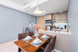 a kitchen and dining room with a wooden table and chairs at Neira by Kozystay - PIK in Jakarta