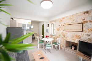 un soggiorno con tavolo e camino di Lagadia Stone House a Ayios Nikitas