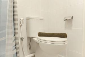 a white toilet in a bathroom with a shower at Cozy Living 2BR at Tokyo Riverside PIK 2 Apartment By Travelio in Rawalembang +13 photos
