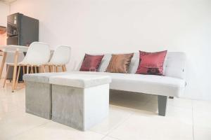 Un sofá blanco con almohadas en una habitación. en Modern and Homey 2BR at MT Haryono Square Apartment By Travelio, en Yakarta