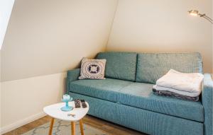 a living room with a blue couch and a table at Lovely Apartment In Timmendorfer-Strand in Timmendorfer Strand +12 photos