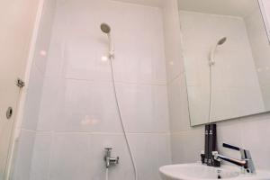 a bathroom with a shower and a sink and a mirror at Nice and Comfort Studio Apartment at Tokyo Riverside PIK 2 By Travelio in Rawalembang +13 photos