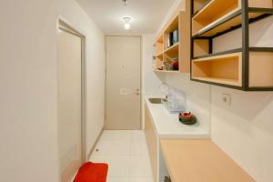 eine kleine weiße Küche mit Theke und Schränken in der Unterkunft Cozy Studio Apartment Tokyo Riverside PIK 2 By Travelio in Rawalembang