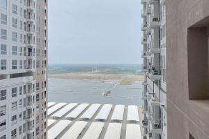 einen Blick auf einen Fluss von zwei Gebäuden in der Unterkunft Cozy Studio Apartment Tokyo Riverside PIK 2 By Travelio in Rawalembang + 4 Fotos