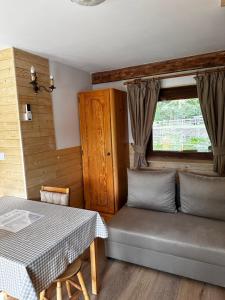 a room with a table and a couch and a window at Domek nad Stawem in Woldenberg Neumark