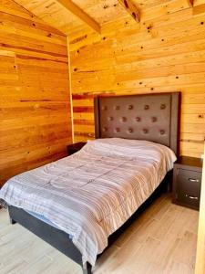 a bedroom with a bed in a wooden room at Cabaña Rincón del Bosque en Durango in Llano Grande +12 photos