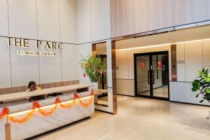 a woman is sitting in the lobby of aenna house at Good Deal Studio at The Parc South City Apartment By Travelio in Tangerang +8 photos