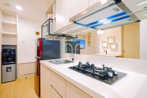 a kitchen with a sink and a stove at Warm and Well Designed 2BR Tokyo Riverside PIK 2 Apartment By Travelio in Rawalembang