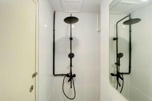 a bathroom with a shower with two shower heads at Comfortable Studio Apartment at Tokyo Riverside PIK 2 By Travelio in Rawalembang