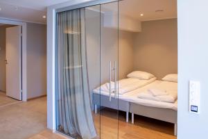 Habitación con cama y pared de cristal. en Avisgata Apartments, en Svolvær