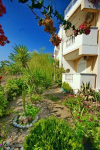 a garden in front of a building with flowers at Paul's Garden Studios in Haraki