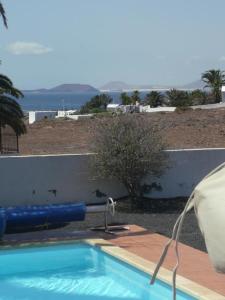 a swimming pool with a water faucet next to a fence at Villa mit Pool und herrlichem Meerblick in Playa Blanca