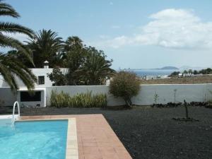 a swimming pool in front of a white house at Villa mit Pool und herrlichem Meerblick in Playa Blanca