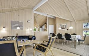 a living room with a couch and a table and chairs at Three-Bedroom Holiday Home In Allinge in Allinge