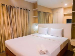 ein Schlafzimmer mit zwei Betten mit weißer Bettwäsche in der Unterkunft Modern and Cozy Studio at Student Park Apartment By Travelio in Seturan