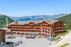 a large building with cars parked in a parking lot at Résidence Les Balcons de Belle Plagne in Belle Plagne