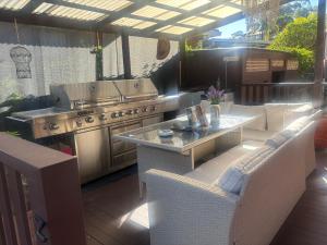 an outdoor patio with a grill and a table and chairs at Wellness Stay in Private Home near beaches, rainforest and South Coast, 2 rooms booked separately in Dapto