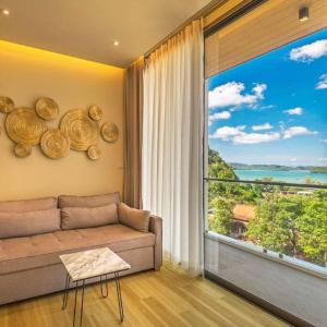 a living room with a couch and a large window at Stunning sea view apartment with pool in Ao Nang Beach