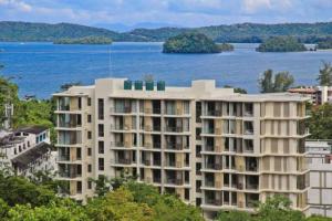 a large apartment building next to a body of water at Stunning sea view apartment with pool in Ao Nang Beach