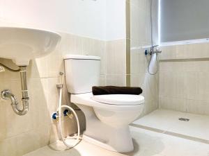 a bathroom with a toilet and a sink at Best Deal and Cozy 3BR Meikarta Apartment By Travelio in Cikarang +18 photos