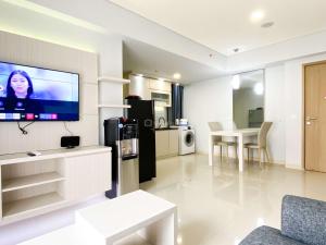 a living room with a flat screen tv on a wall at Best Deal and Cozy 3BR Meikarta Apartment By Travelio in Cikarang