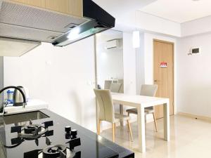 a kitchen and dining room with a table and chairs at Best Deal and Cozy 3BR Meikarta Apartment By Travelio in Cikarang