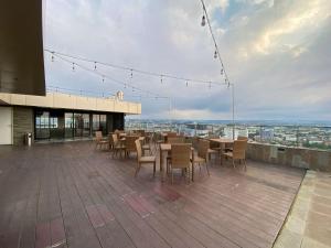 a rooftop patio with tables and chairs on a building at Good Choice and Modern Studio Marquis de Lafayette Apartment By Travelio in Semarang