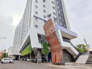 a tall white building with a sign on it at Comfy and Modern Studio at Cordova Edupartment Semarang Apartment By Travelio in Semarang