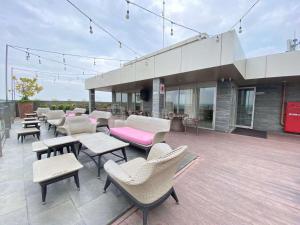 a patio with chairs and tables on a building at Homey and Comfort Living Studio Apartment Warhol (W/R) Residences By Travelio in Semarang