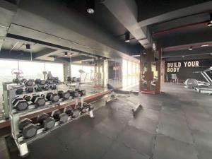 a gym with several rows of dumbbells at Homey and Comfort Living Studio Apartment Warhol (W/R) Residences By Travelio in Semarang