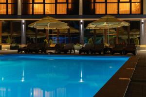 a hotel swimming pool with chairs and umbrellas at Toga in Yablunytsya