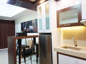 PampangにあるLuxury 2BR at Vida View Makassar Apartment By Travelioのシンクとバー付きのキッチンが備わります。