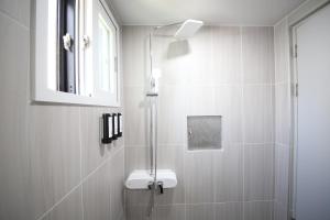 a bathroom with a shower with a sink and a mirror at Calm Rest Hotel Masan in Changwon +43 photos