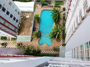 PampangにあるLuxury 2BR at Vida View Makassar Apartment By Travelioの2棟の建物の間にあるスイミングプールのオーバーヘッドビュー