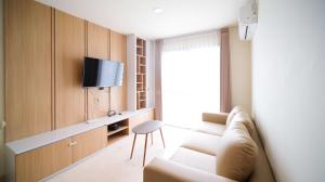 a living room with a couch and a tv at Best Location and Strategic 2BR at Praxis Apartment By Travelio in Surabaya
