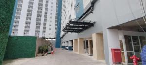 an empty hallway of a building with tall buildings at New Studio Apartment with Strategic Location at Suncity Residence By Travelio in Sidoarjo