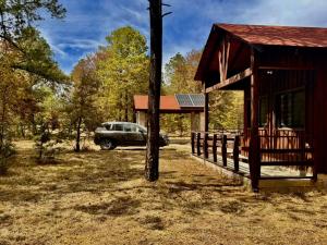 a car parked next to a cabin with a car parked outside at Cabaña Rincón del Bosque en Durango in Llano Grande