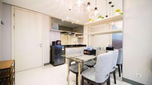 a kitchen and dining room with a table and chairs at Clean and Comfort Living 2BR at Anderson Supermall Mansion Apartment By Travelio in Surabaya