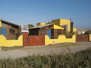 eine Reihe von Häusern mit gelben Wänden und einem Zaun in der Unterkunft Cabañas Caleta San Pedro in La Serena