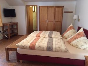 a bedroom with a bed and a television in a room at Die Hardtmühle in Bergfreiheit