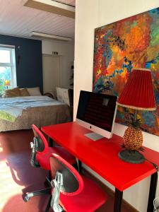 Un dormitorio con un escritorio rojo con una computadora encima. en Enchanted property by the Viking stones, en Västra Strö
