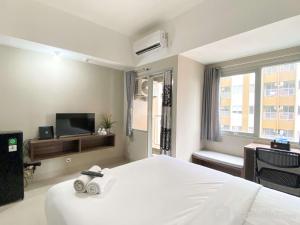 Televisyen dan/atau pusat hiburan di Modern Look Studio Room at Gateway Park LRT City Jatibening Apartment By Travelio