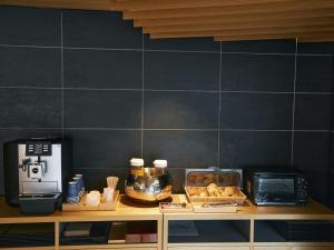 un bancone in cucina con macchinetta del caffè e cibo di Hotel Traveltine Kyoto Kiyamachi a Kyoto