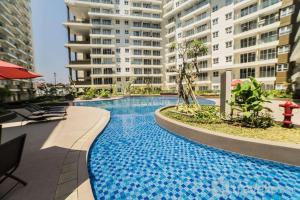 a large swimming pool in the middle of a building at Spacious 3BR at Gateway Pasteur Apartment By Travelio in Bandung