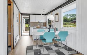 a kitchen with a white table and blue chairs at Ravnen in Hasle