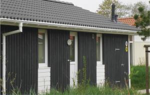 a black and white house with a white door at Dünenpark 1C - Dorf 4 in Travemünde +18 photos