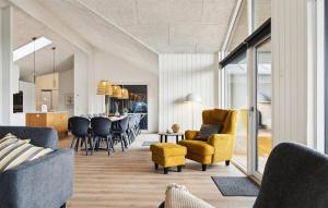 soggiorno a pianta aperta e sala da pranzo con sedie gialle di Stunning Home In Ålbæk With Sauna ad Ålbæk