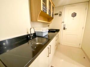 三宝垄Minimalist Studio Room Marquis de Lafayette Apartment By Travelio的厨房配有水槽和黑色台面 更多5张照片