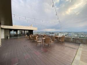 三宝垄Minimalist Studio Room Marquis de Lafayette Apartment By Travelio的大楼内带桌椅的屋顶露台